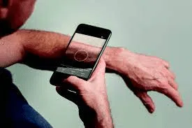 Person taking photo of wrist with smartphone