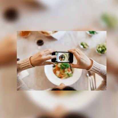 Hands taking smartphone photo of salad