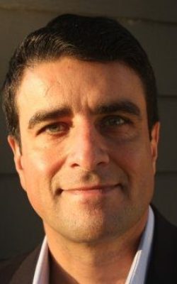Headshot of smiling man in blazer